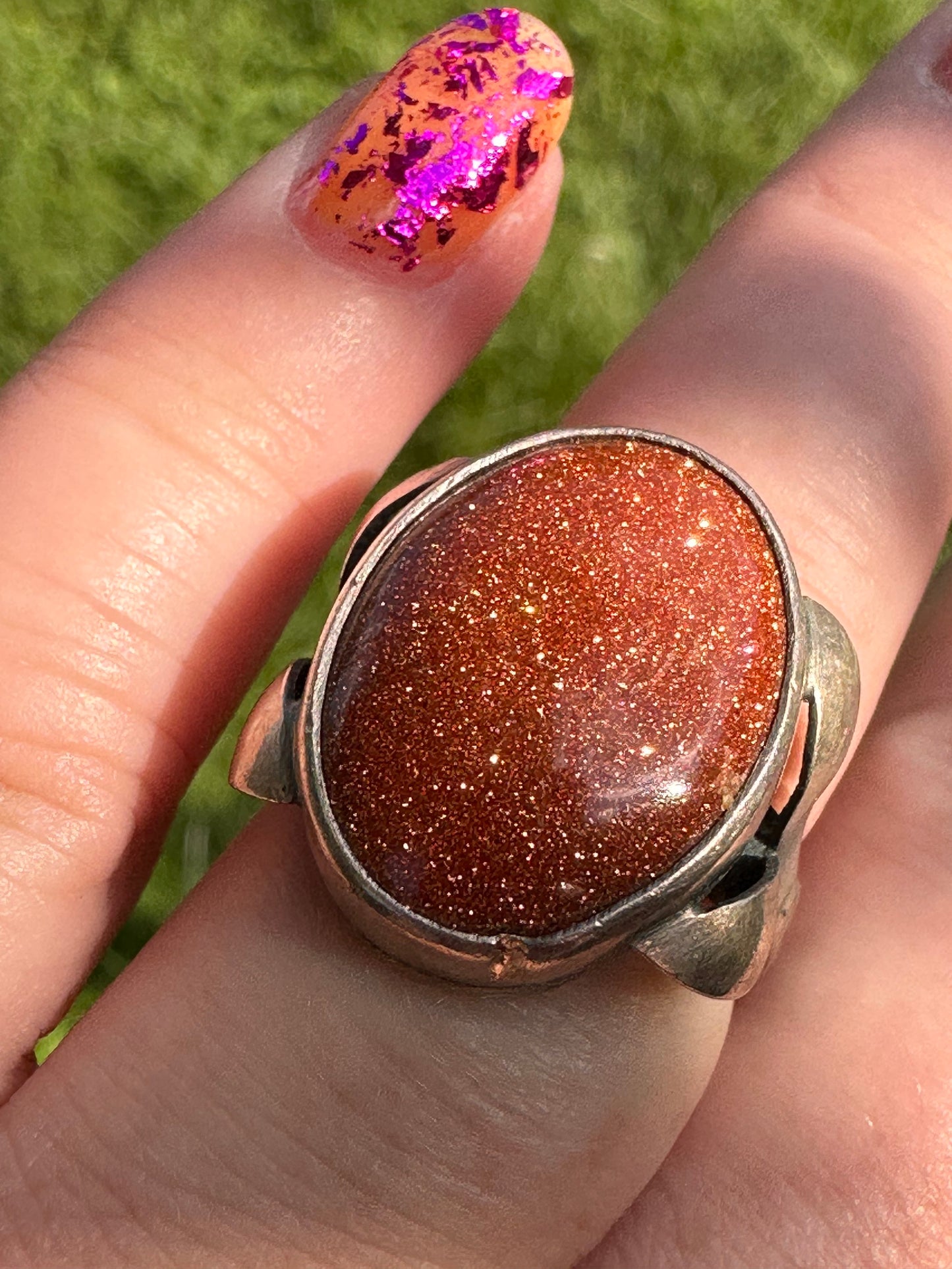 Goldstone set in fanciful floral stamped silver band sz. 7.5